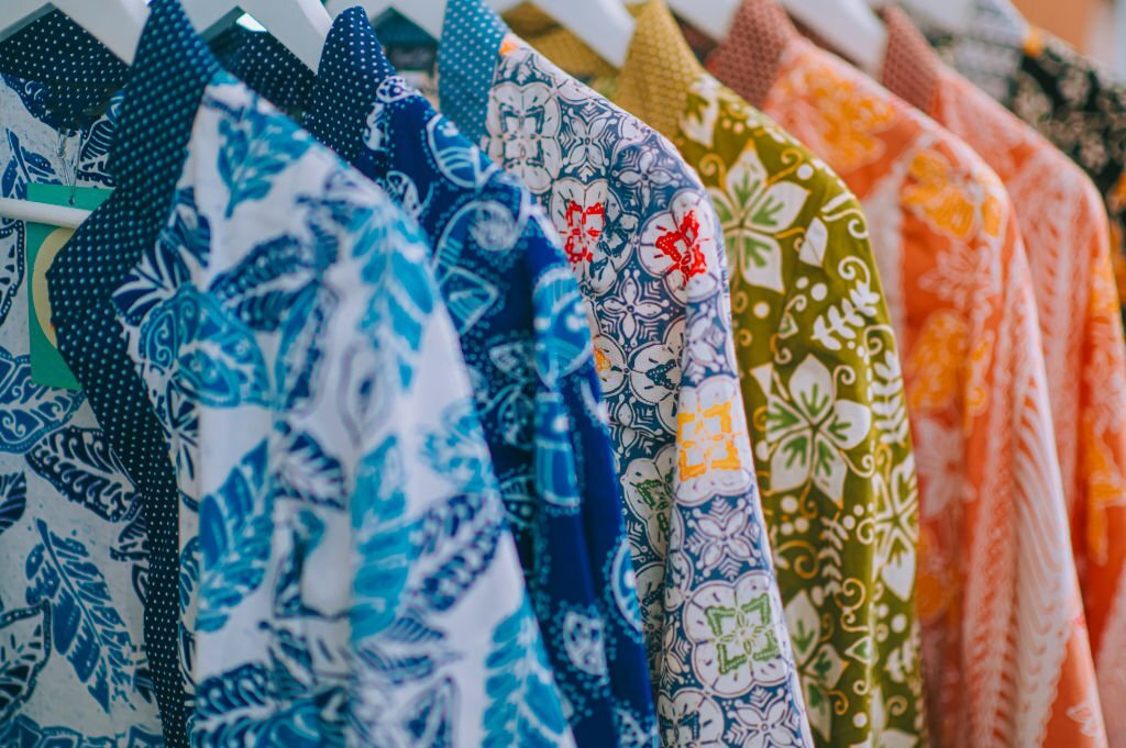 Koleksi seragam batik custom Pabrik Batik tergantung di rak
