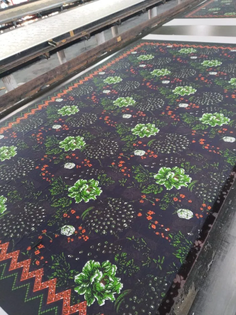 Kain batik dalam proses pencetakan di meja produksi